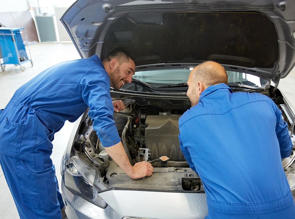 Mechanics looking under a vehicles bonnet - Car Servicing Colwyn Bay